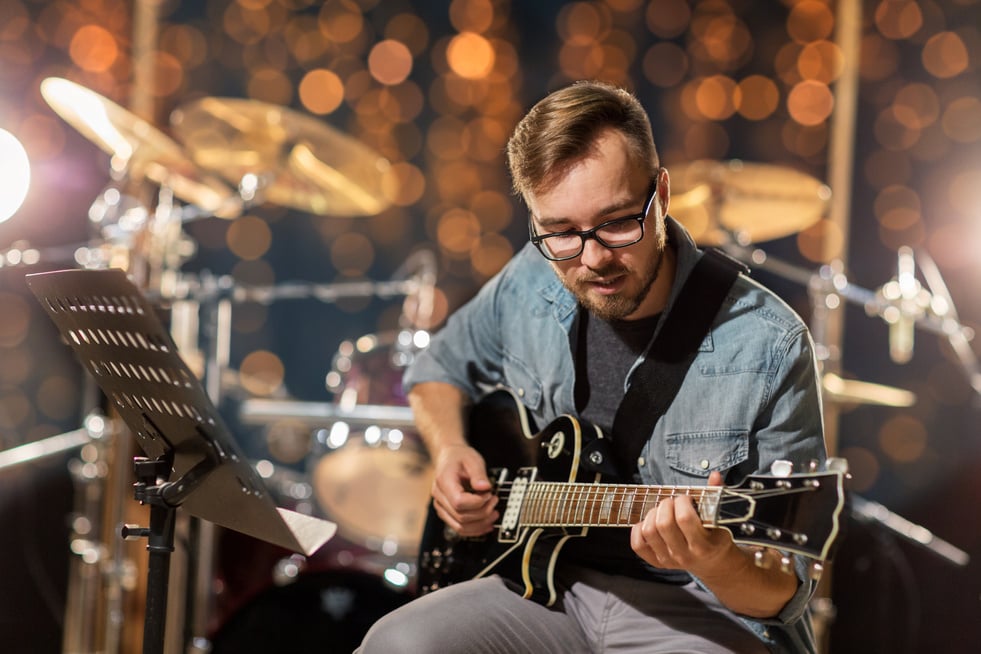 Musician Playing Guitar at Studio 